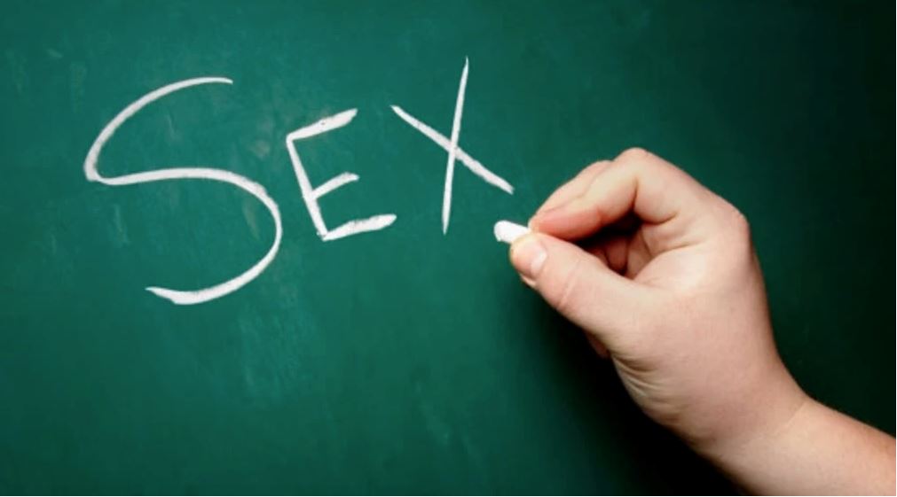 someone writing 'sex' on a chalkboard