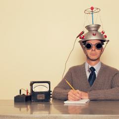 man with colander on his head with a piece of paper